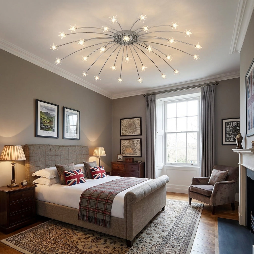 A modern ceiling light fixture with multiple thin chrome metal arms radiating from a central chrome hub, each ending in a small glowing star bulb, installed in a styled bedroom with grey walls, a bed, lamps, and a window.