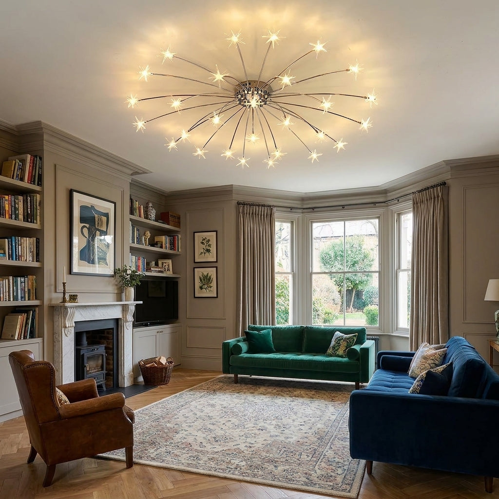 A large multi-light starburst chandelier with glowing bulbs hangs in a spacious, elegantly decorated living room featuring a green velvet sofa, a blue sofa, a brown leather armchair, and a patterned area rug.