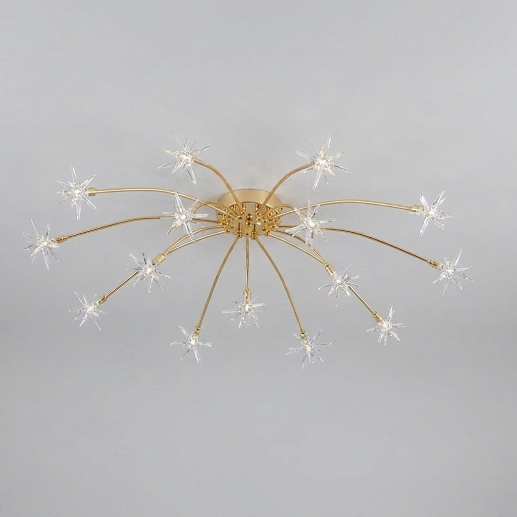 A modern ceiling light fixture with a gold-finished central canopy and multiple thin radial arms ending in clear starburst-shaped glass shades, shown against a plain light grey background.