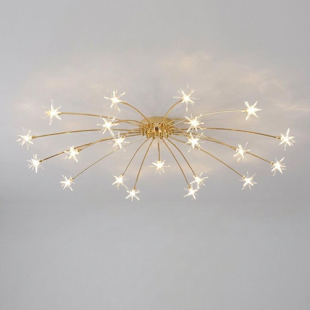 A modern ceiling light fixture with a gold-finished central hub and multiple thin radiating arms ending in starburst-shaped glass shades, shown lit against a plain light grey ceiling.
