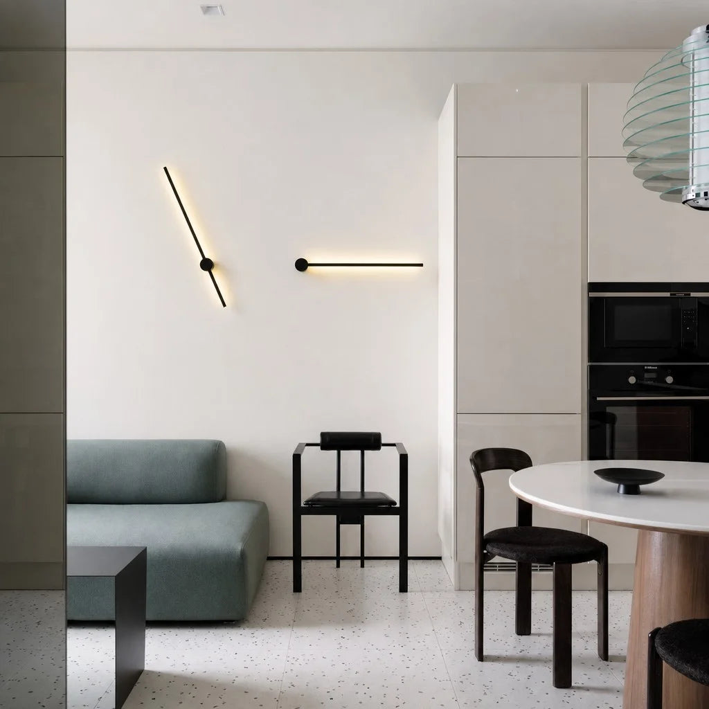 Adjustable linear LED wall sconces mounted at creative angles in a modern open-plan dining and living area
