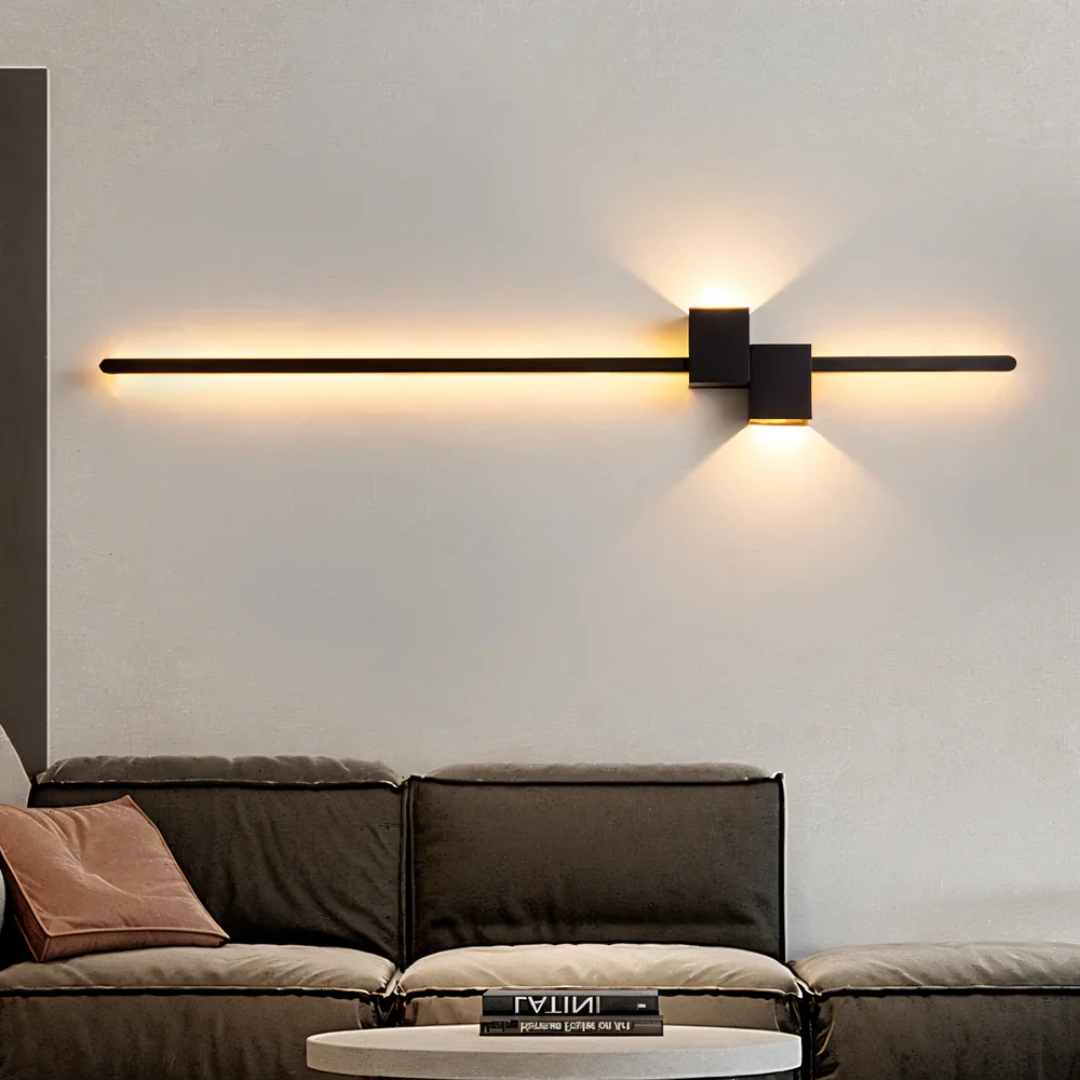 Black horizontal asymmetrical aexi wall light casting a warm geometric glow above a minimalist living room sofa