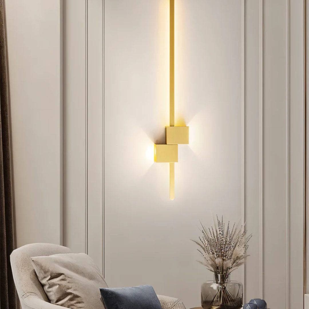 Elegant vertical gold asymmetrical aexi wall sconce illuminating a panelled living room wall