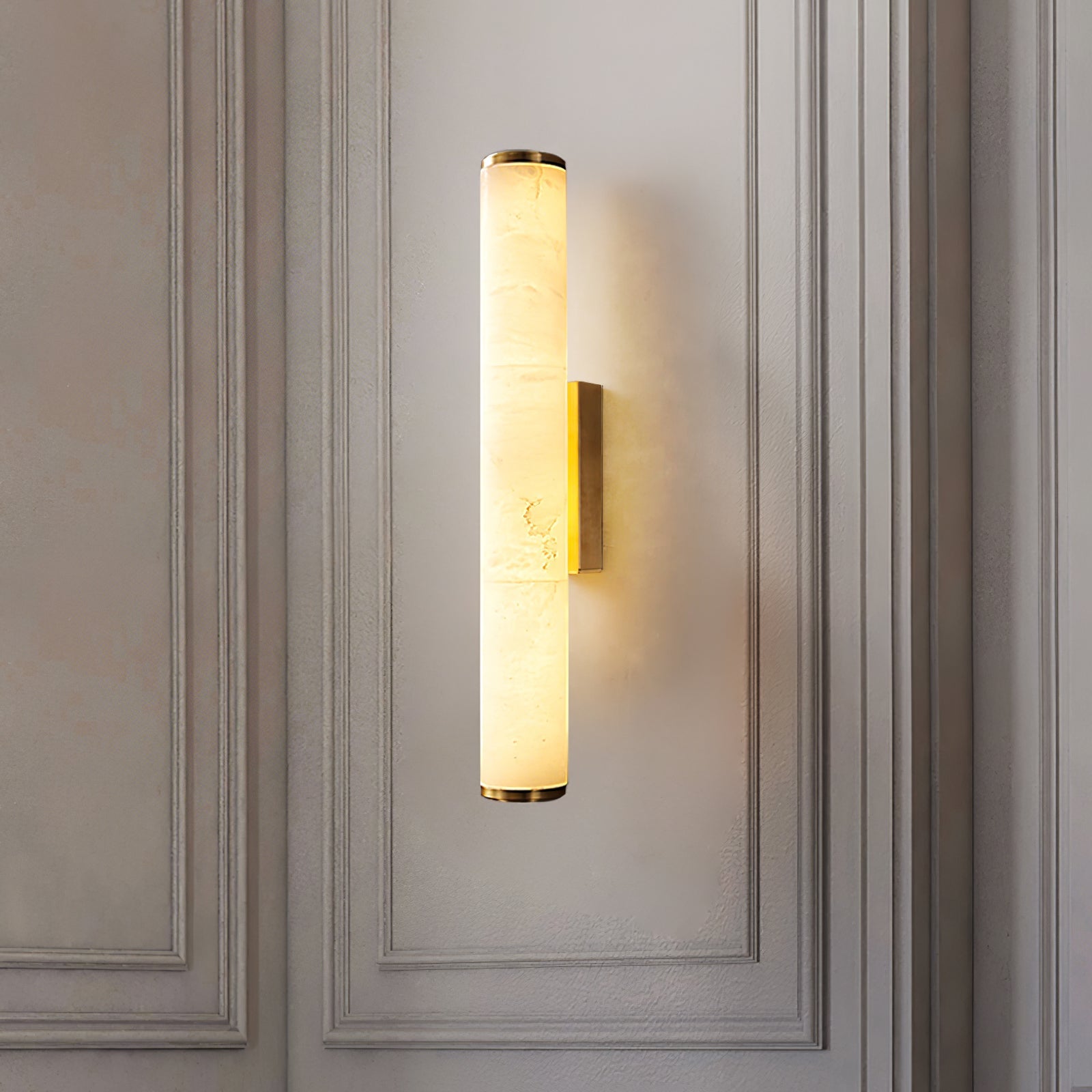 Alabaster cylinder wall sconce installed vertically on a classic light grey panelled wall