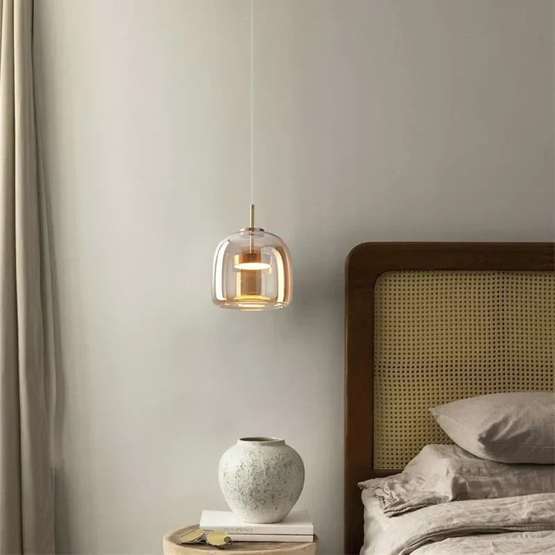 Single amber tinted glass pendant styled as an elegant, space-saving bedside reading light