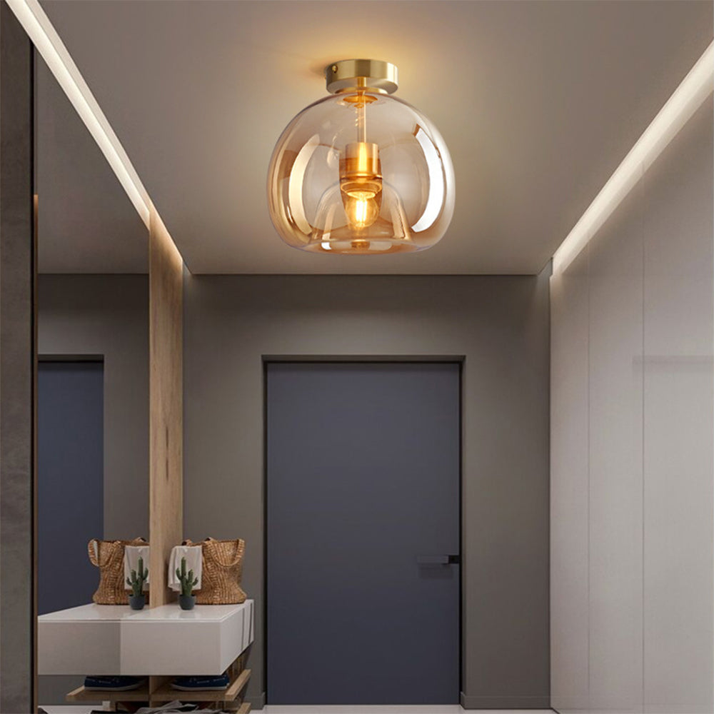 Warm amber glass compact flush mount ceiling light above a modern vanity washroom space