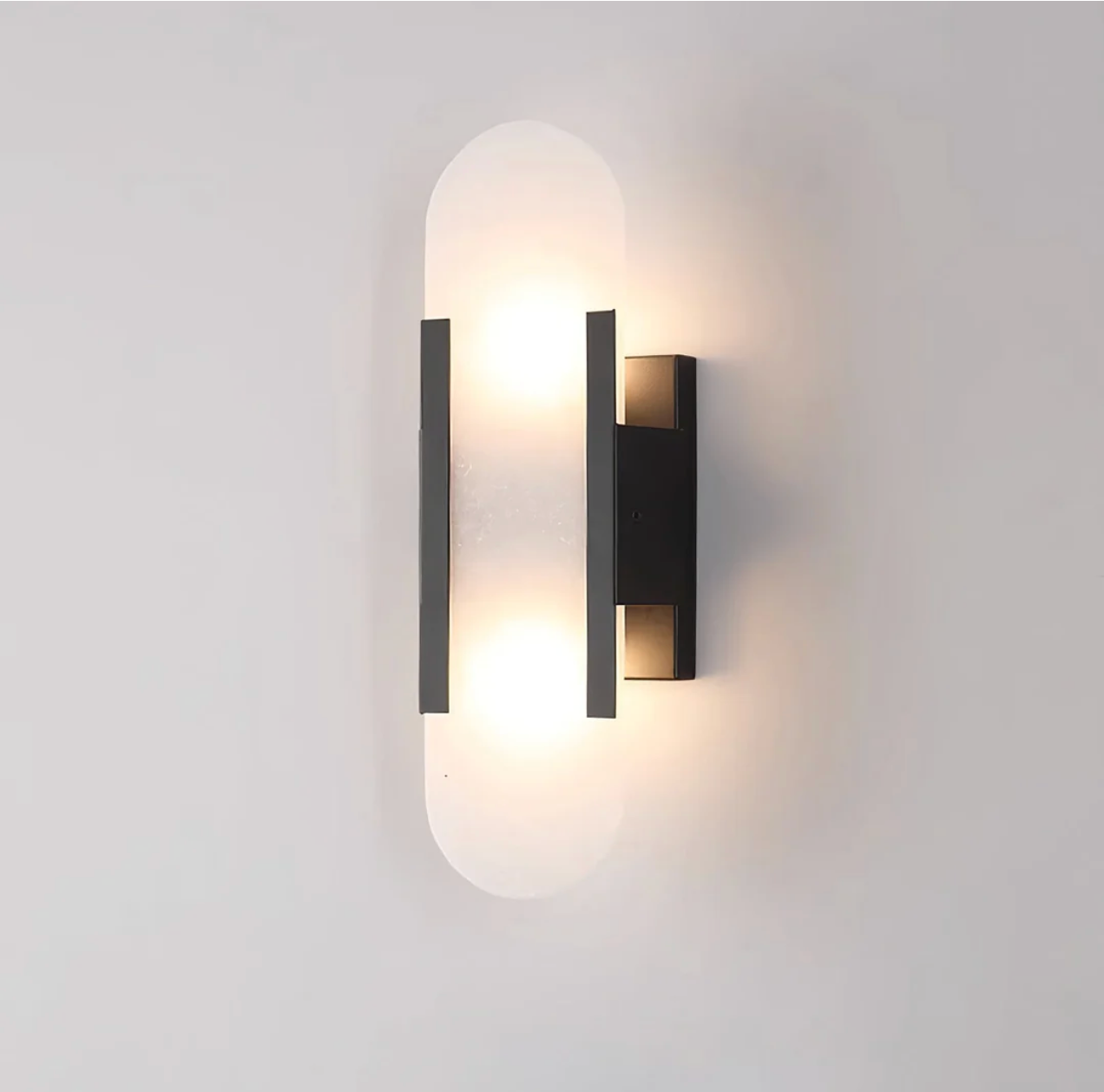 Angled view of the minimalist black marble capsule wall light