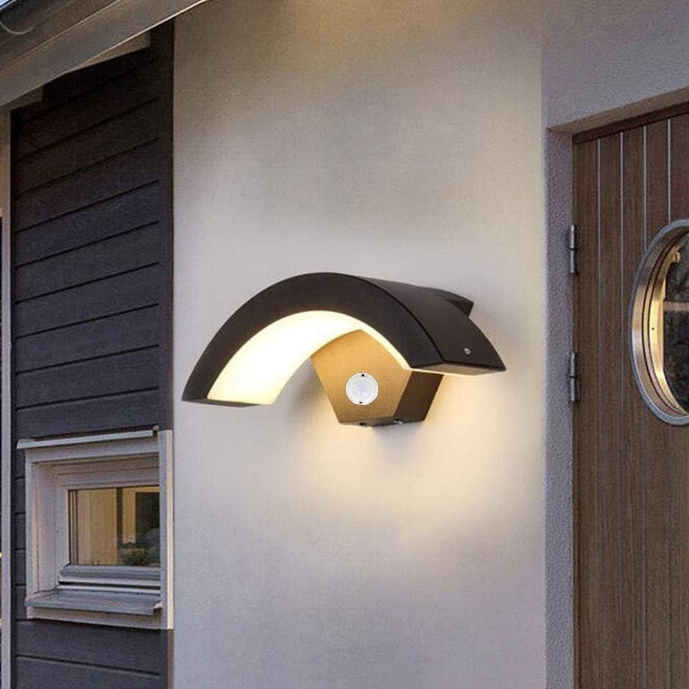 Black arched exterior sconce with motion sensor installed on a modern home facade