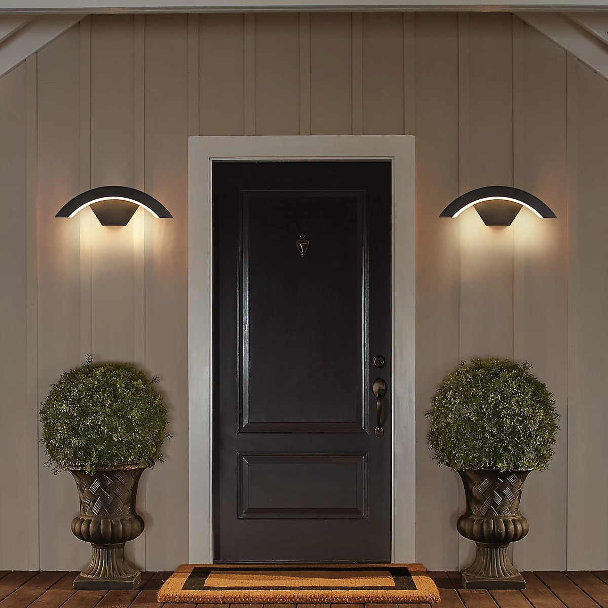 Pair of modern arched outdoor porch lights flanking a classic dark front door