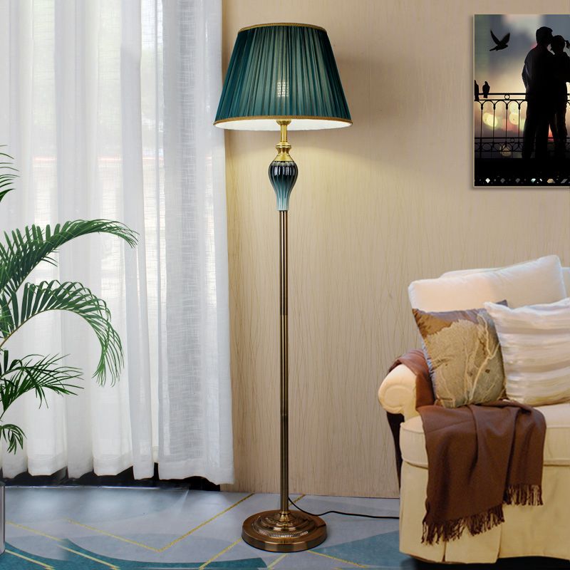 Military green classic dome shade reading floor light positioned next to a living room sofa