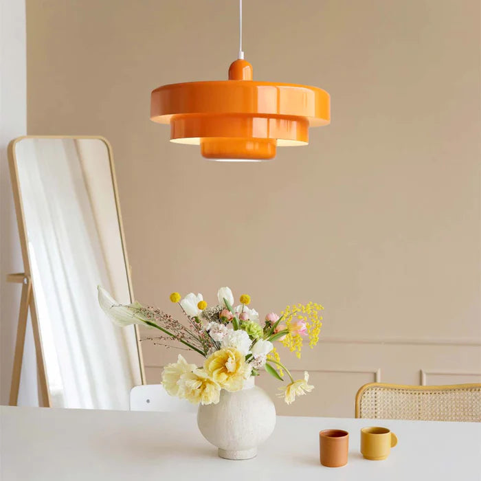 Vibrant orange Bauhaus balel tiered pendant light adding a pop of colour above a minimalist vanity table