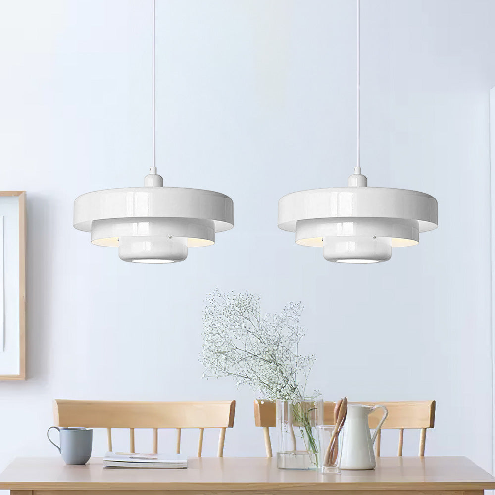 Pair of white Bauhaus tiered balel pendant lights illuminating a modern minimalist dining table