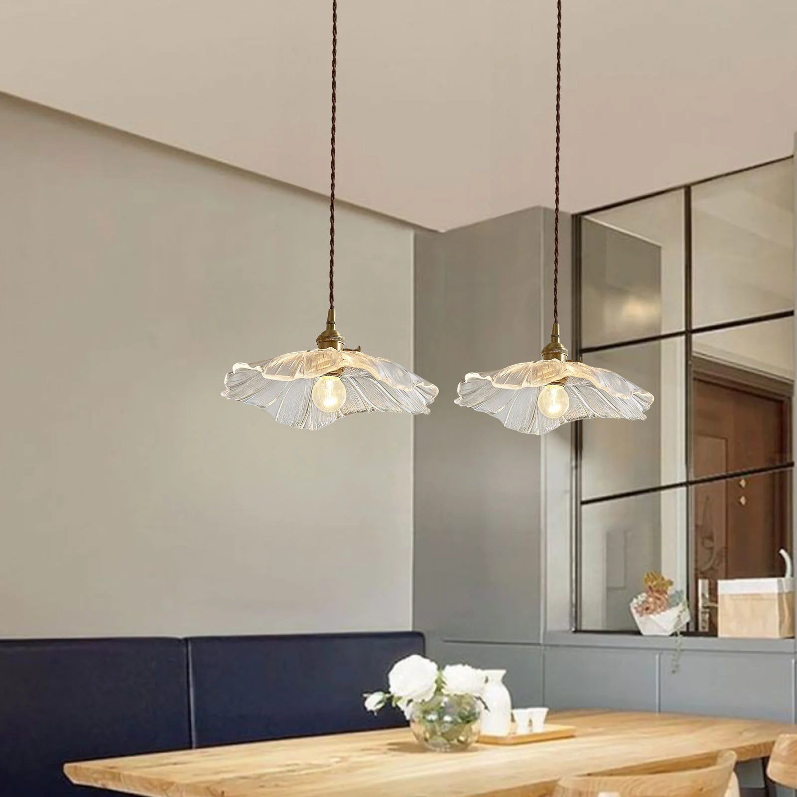 Pair of clear fluted bila glass pendant lights illuminating a sophisticated dining space