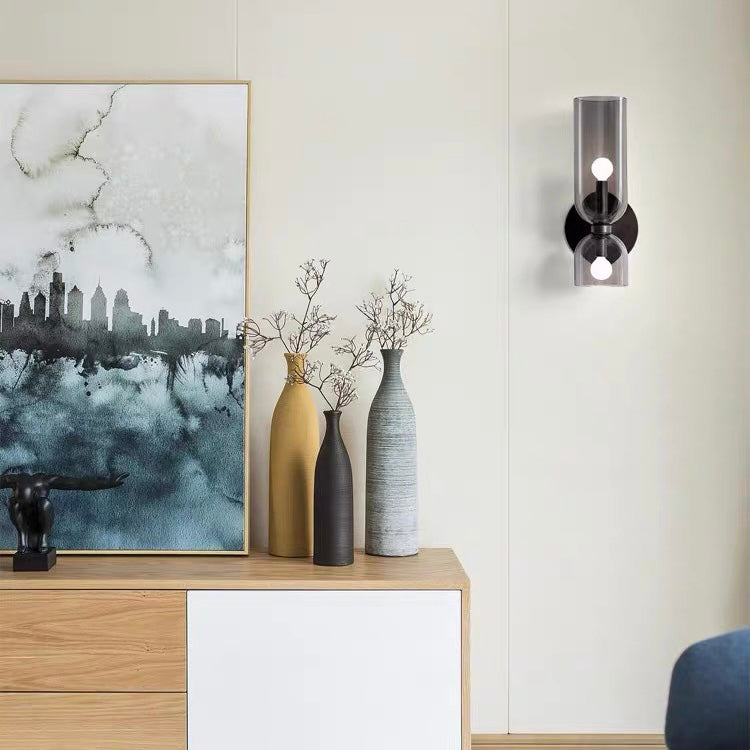 Grey bitlat hourglass glass double wall sconce illuminating a modern living room sideboard area