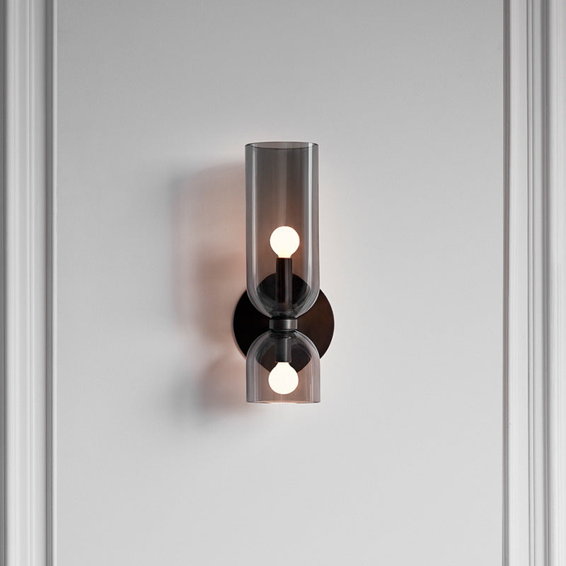 Grey bitlat tinted glass retro wall sconce mounted vertically on a light grey panelled wall