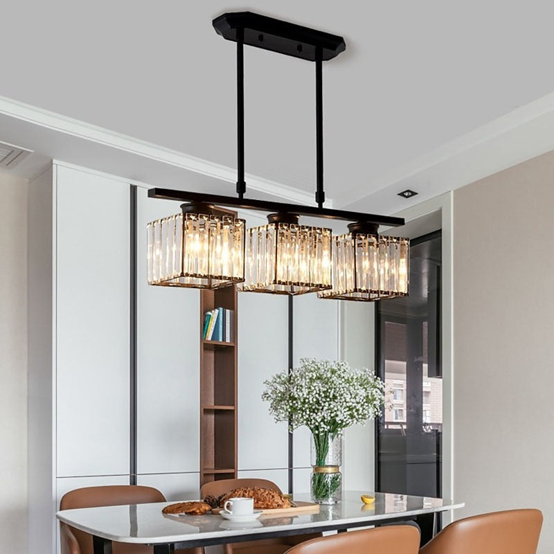 Black 3-light linear glass pendant providing warm lighting over a contemporary kitchen table