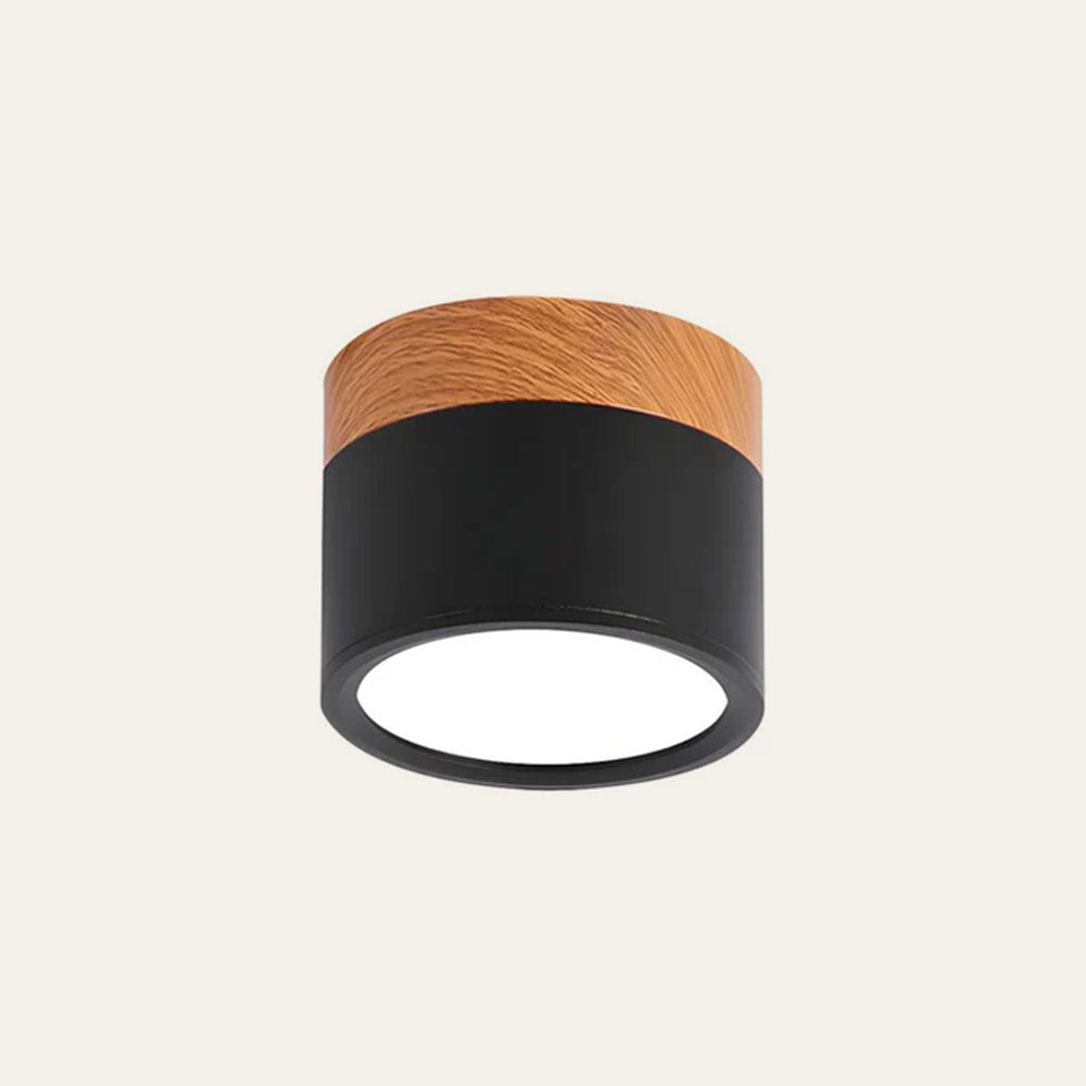 Close-up of a matte black aluminium cylinder flush ceiling light with wood-effect trim
