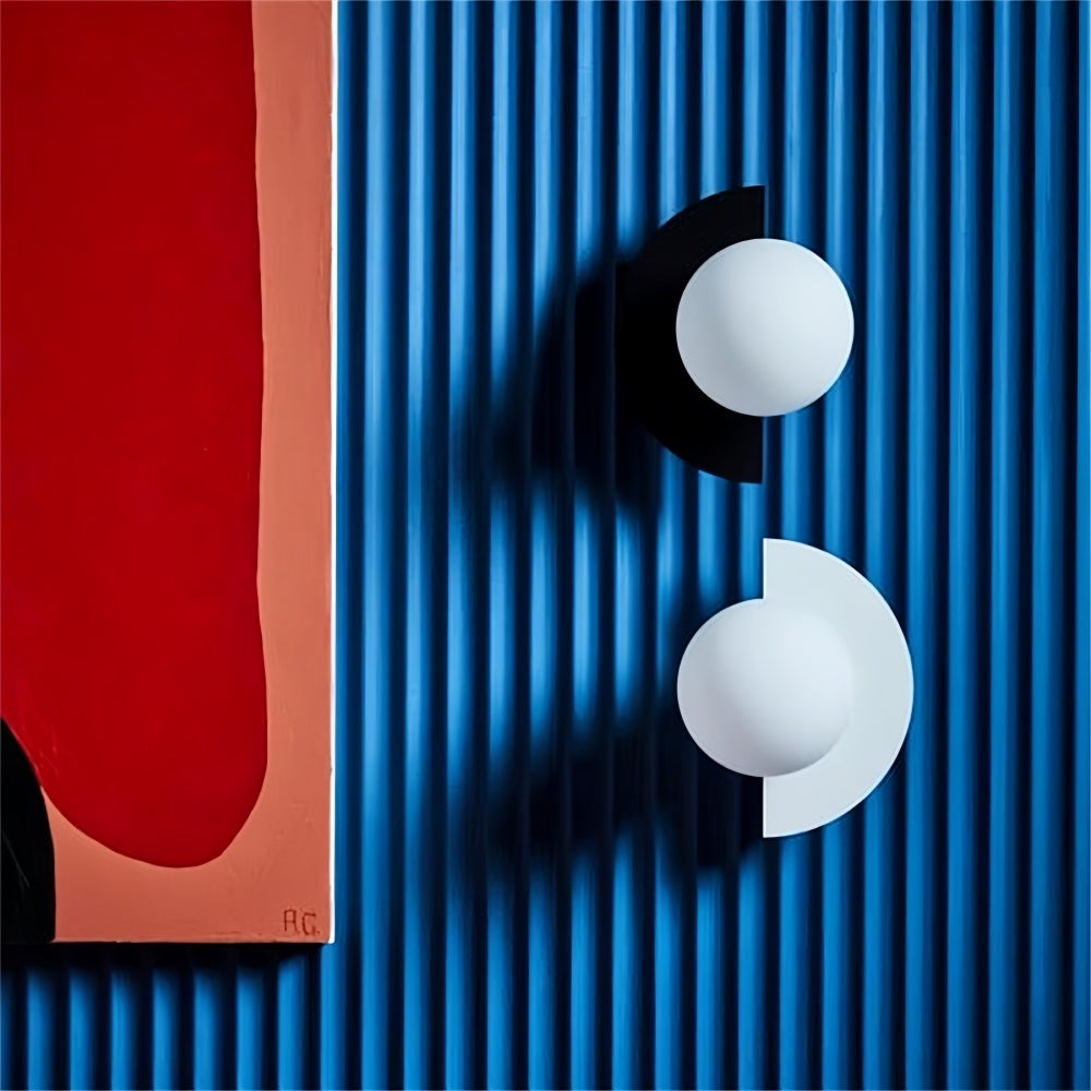 Black and white frosted glass globe sconces contrasting beautifully against a blue ribbed accent wall
