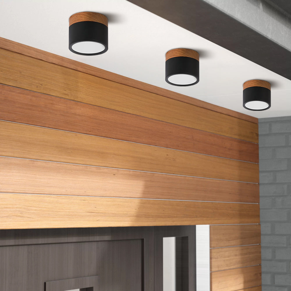 Black cylinder surface-mounted spotlights installed on a modern ceiling