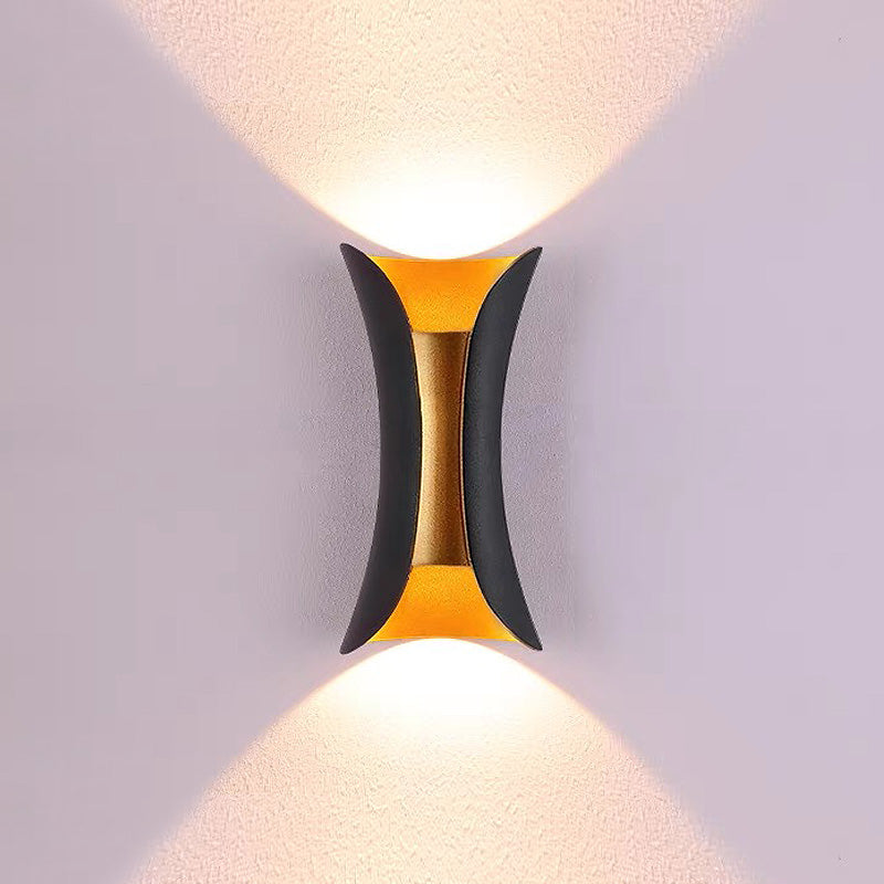 Black and gold architectural wall washing light with a distinct pinched centre silhouette