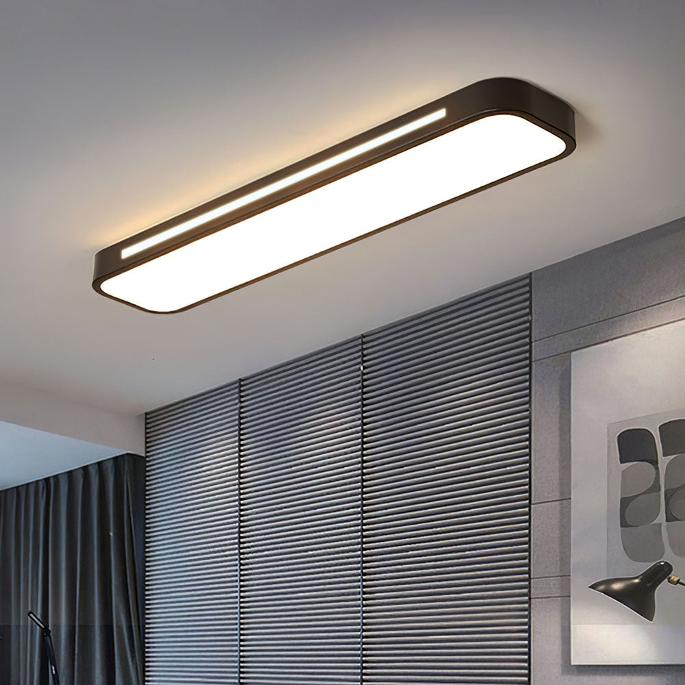Black modern linear LED ceiling lamp installed in a room featuring grey slatted wall panels