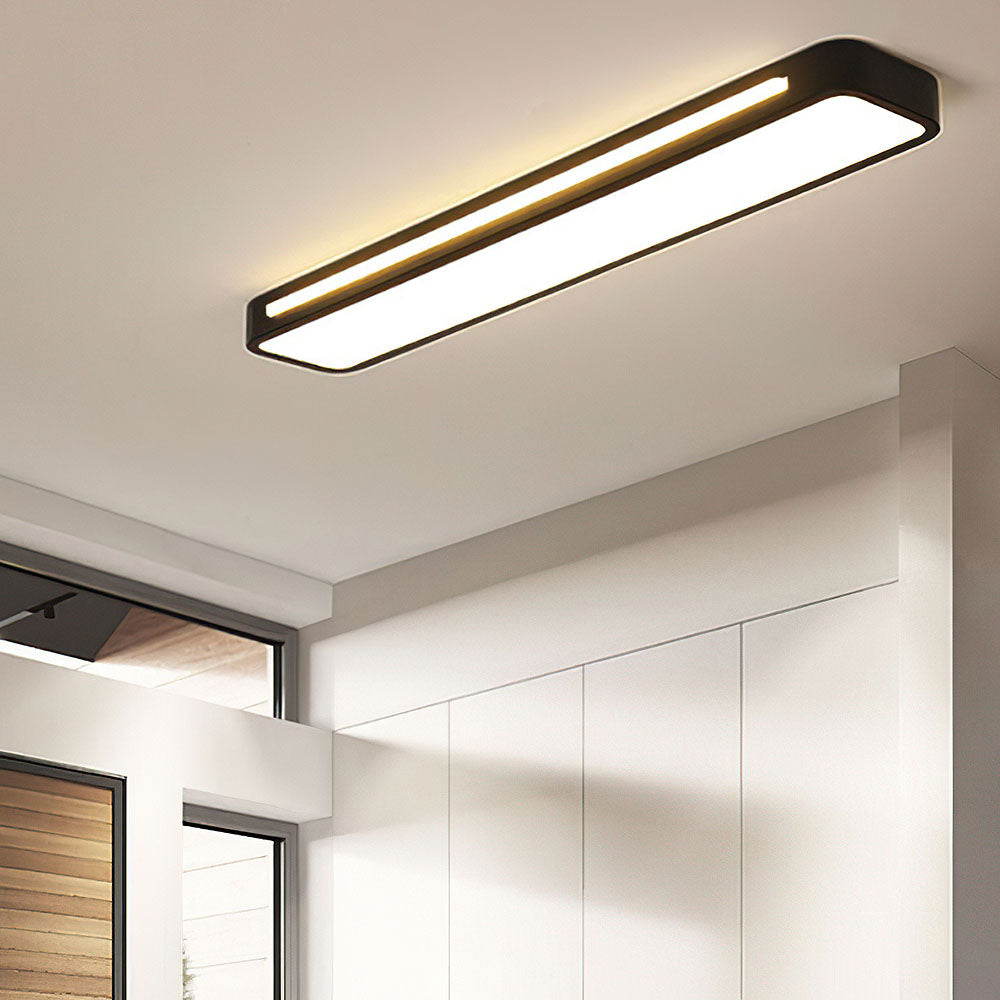 Minimalist black linear LED ceiling light providing task lighting in a modern kitchen corridor