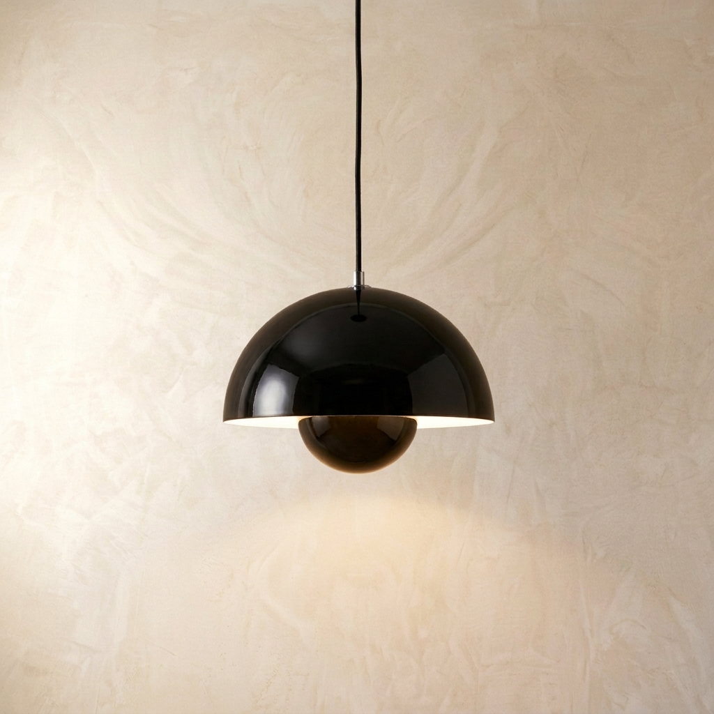 Modern black mid-century flowerpot pendant light casting a warm downward glow against a textured wall