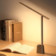 Modern black foldable LED desk lamp providing glare-free reading light over an open book