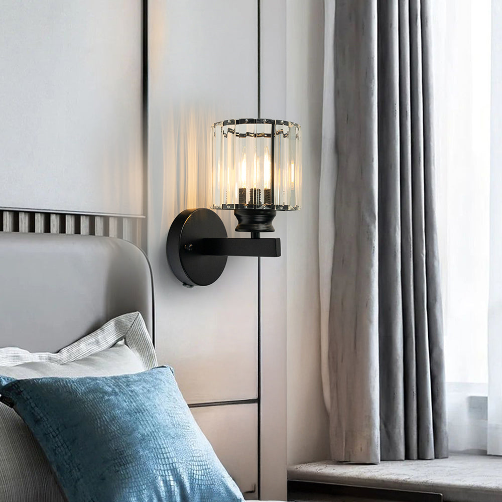Black round crystal wall sconce installed as elegant bedside lighting next to a headboard