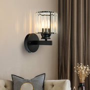 Modern black round crystal wall sconce providing warm ambient light above a sofa in a living room