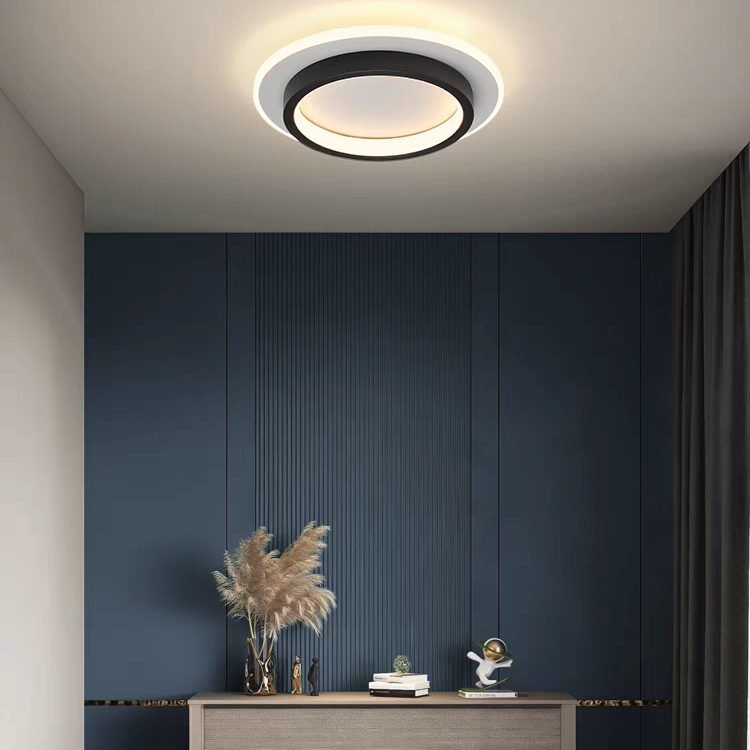 Black round geometric flush mount ceiling light illuminating a bedroom with a dark blue accent wall