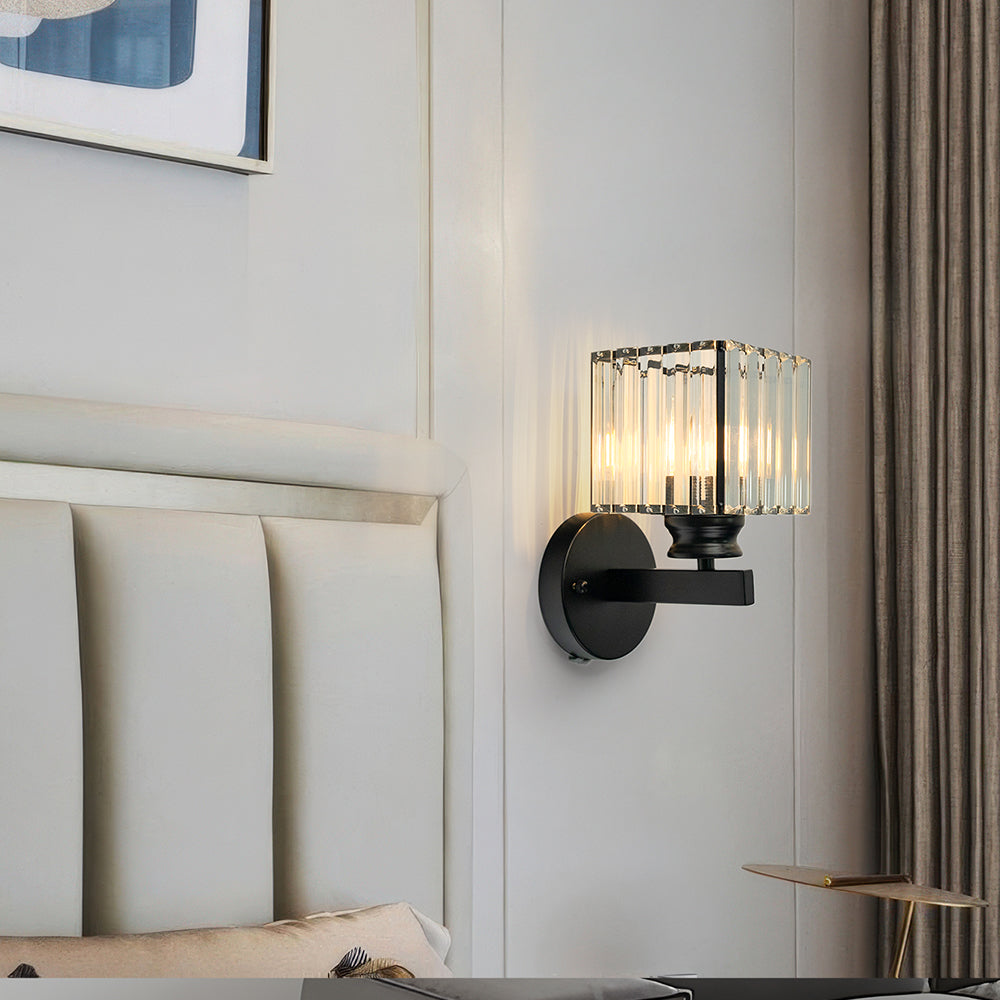Illuminated black square crystal wall sconce showing beautiful light refractions on a white wall