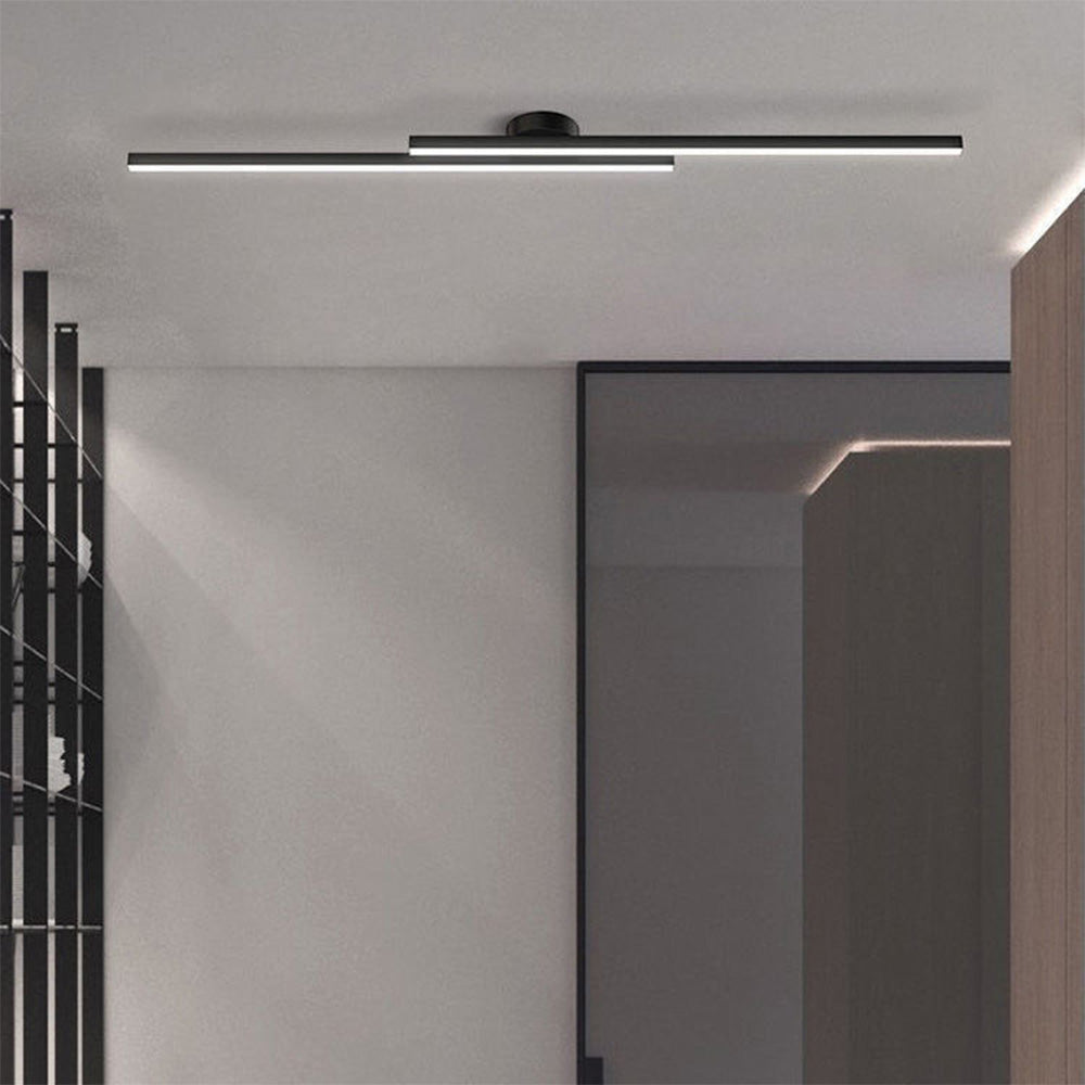 Black staggered linear ceiling fixture providing sleek architectural lighting in a grey room