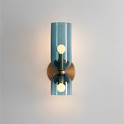 Modern blue tinted glass hourglass wall sconce providing up and down lighting against a light wall