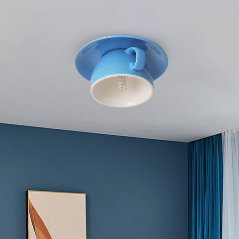 Blue novelty coffee cup flush mount light illuminating a contemporary blue living room space