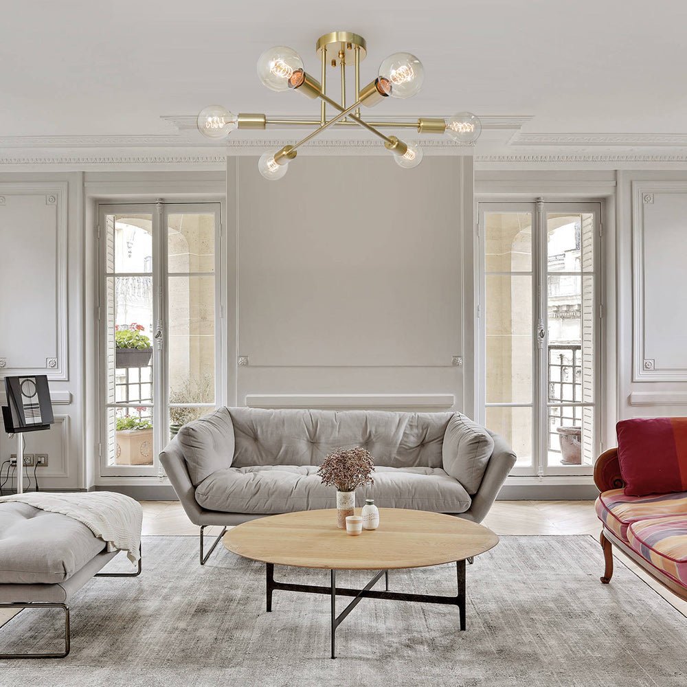Brass Sputnik chandelier providing warm ambient lighting over a coffee table in a modern grey living room