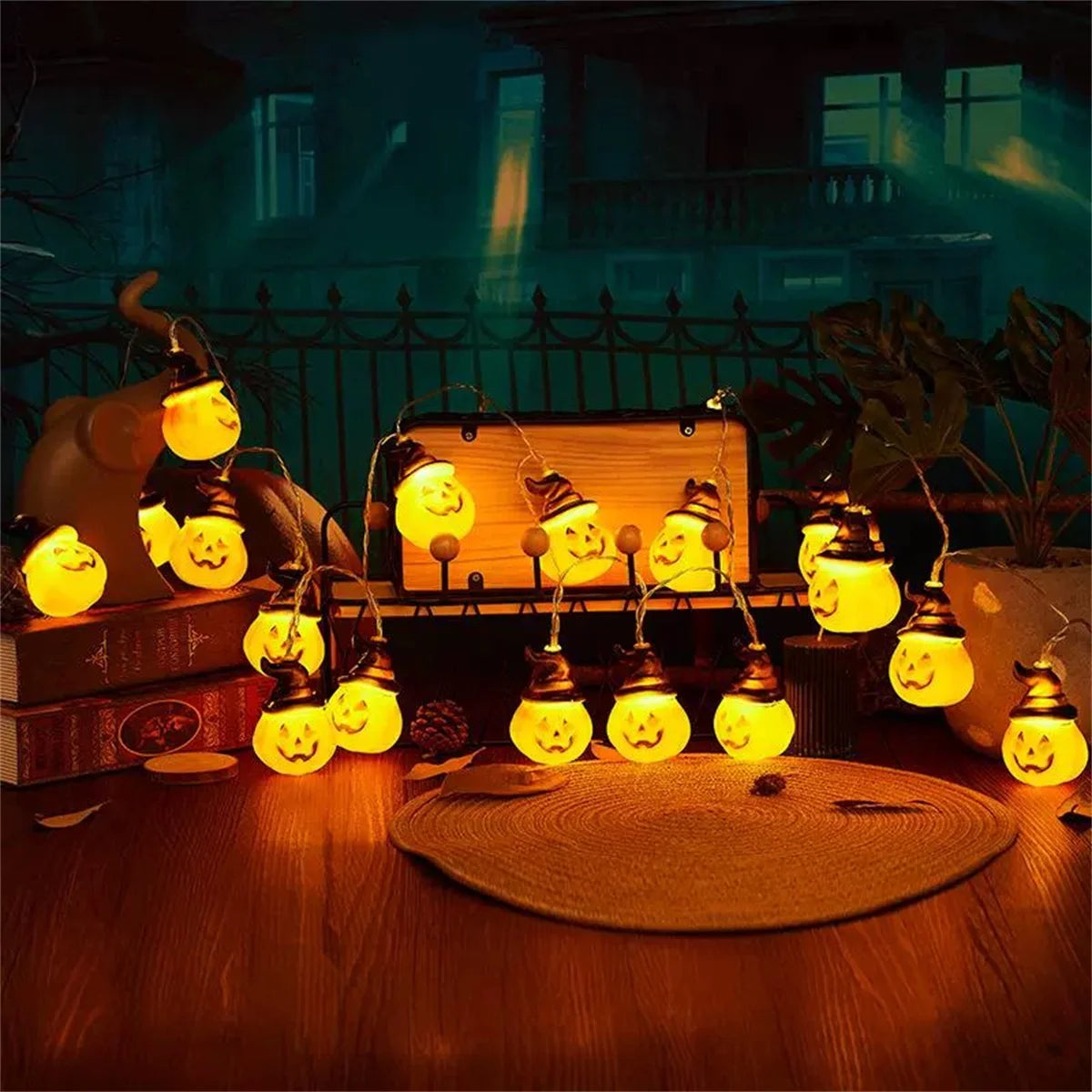 Brimsparks pumpkin-shaped LED string lights glowing on a table with an owl figurine and haunted house backdrop