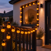 Brimsparks pumpkin-shaped LED string lights draped along a porch railing and window frame at dusk