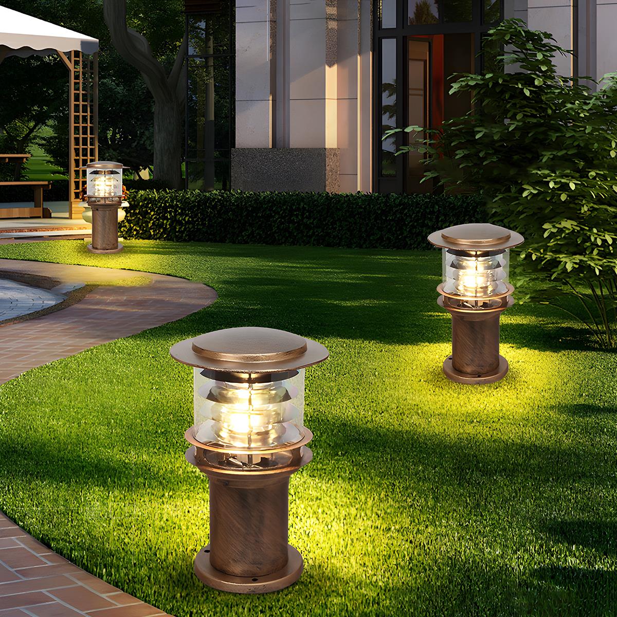 Two bronze solar garden pillars providing soft landscape lighting on a lush green lawn