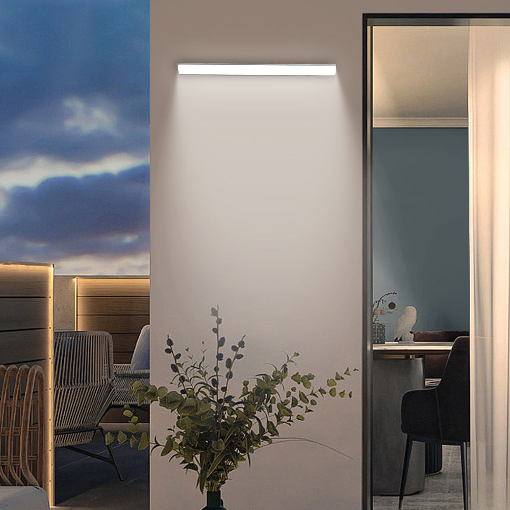 Long front-lit bubce LED wall light illuminating a modern apartment balcony at twilight