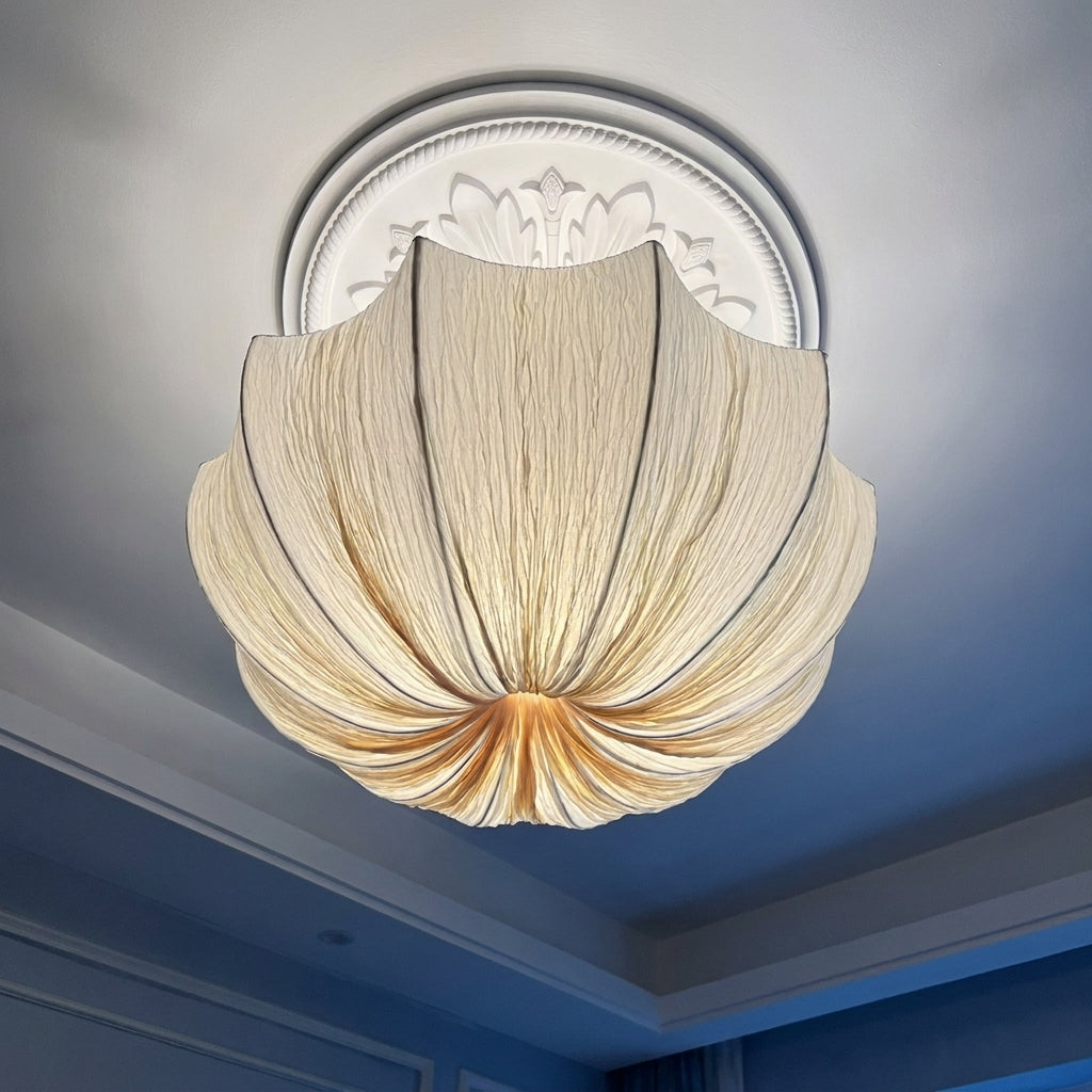 Close-up upward view of the lit Buvla pleated fabric pendant light against the ceiling