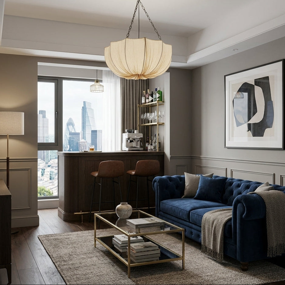 Buvla pleated fabric pendant light lit in a living room with dark wood accents