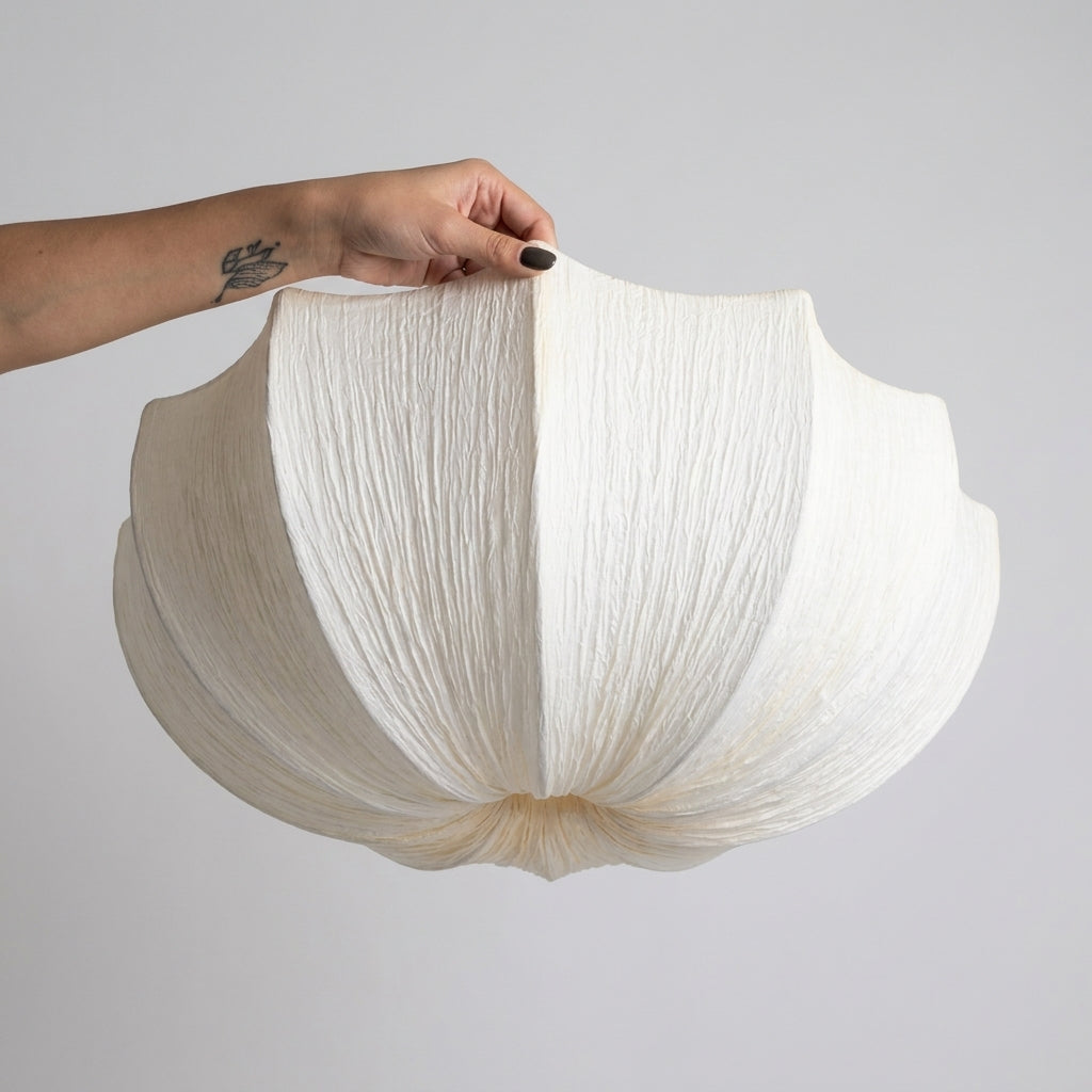 Close-up of the pleated fabric texture on the Buvla bowl pendant shade, held by hand