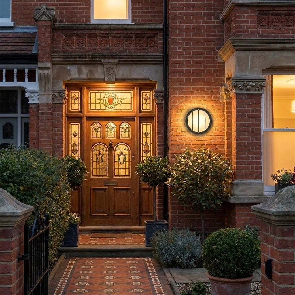 Byrzi outdoor wall light beside a traditional wooden front door