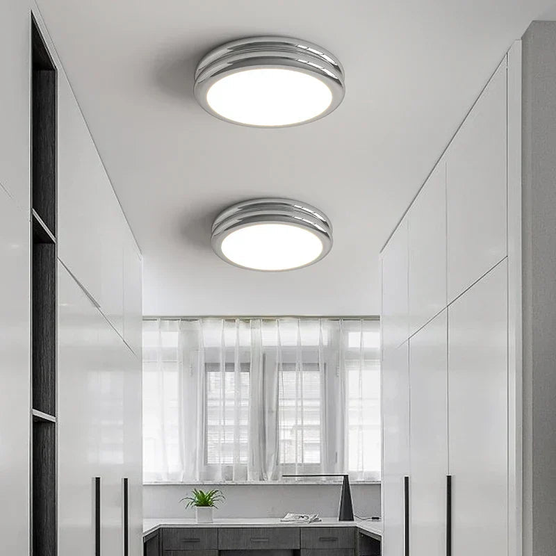 Chrome double-ring LED ceiling lamps adding a sleek, modern touch to a white corridor