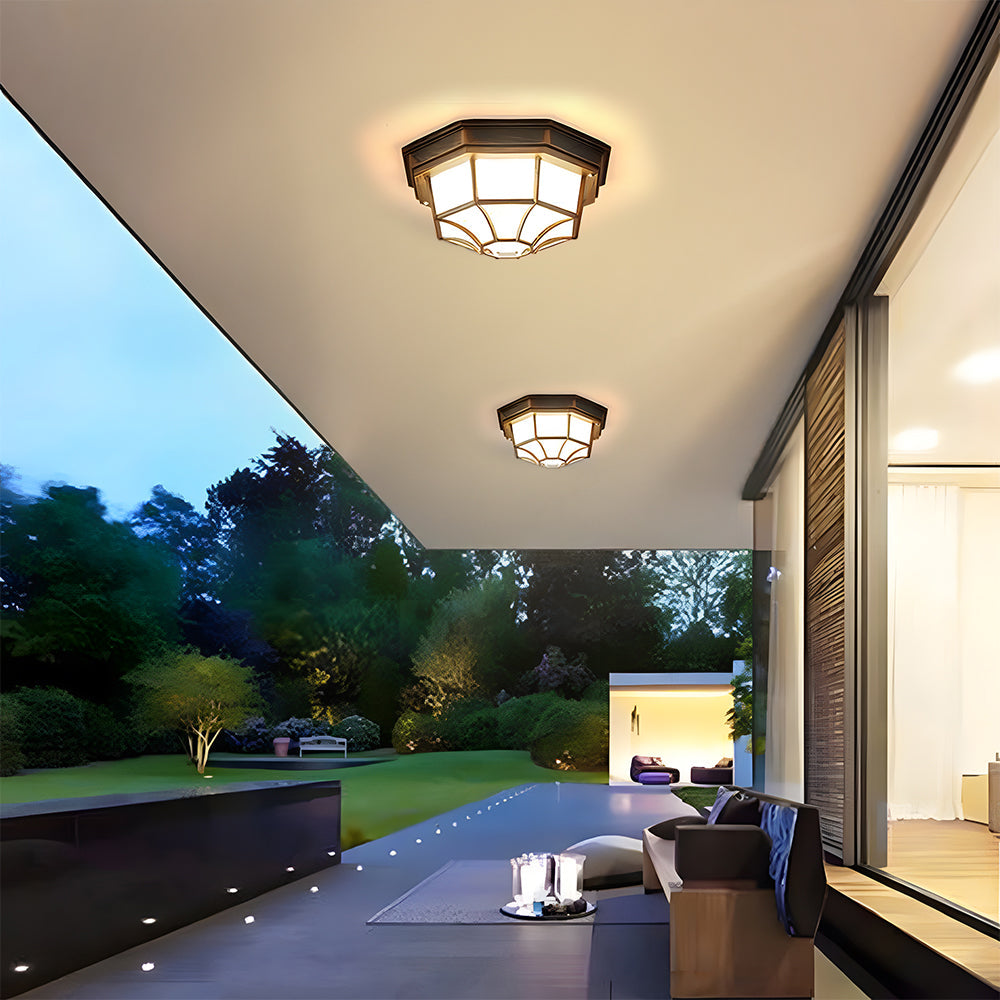 Modern patio and pergola illuminated by bronze cila exterior bulkhead ceiling lighting at twilight