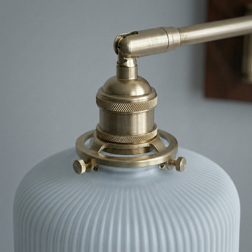 Close-up of Cizqa's brass swing arm joint and ceramic shade detail