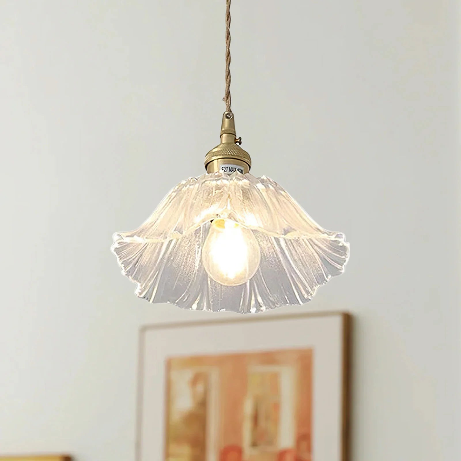 Clear vintage lotus glass pendant light with a fluted retro design glowing softly