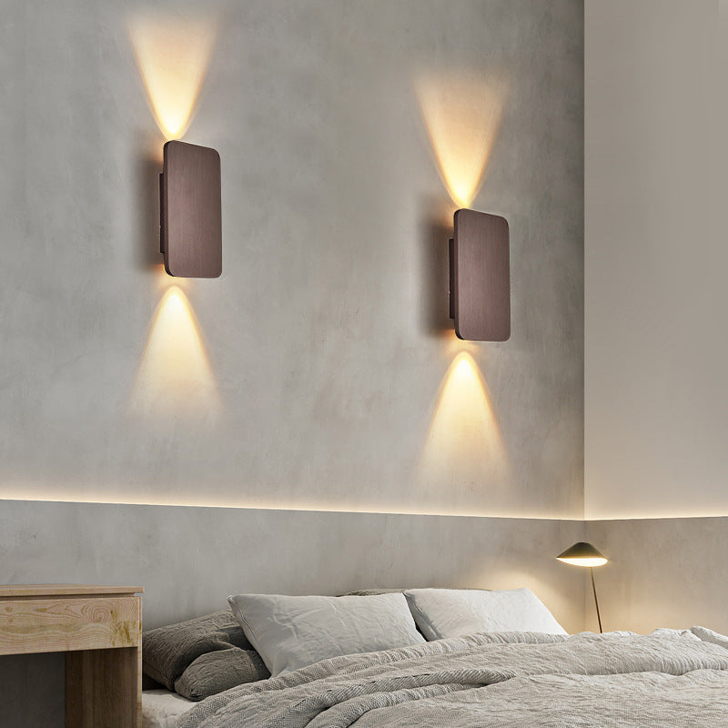 Pair of coffee brown rectangular wall sconces used as ambient bedroom lighting over a bed