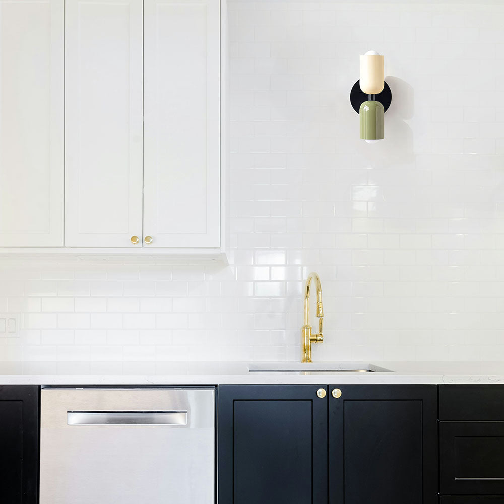 Colour-block glass wall sconce adding a retro mid-century touch to a minimalist white kitchen